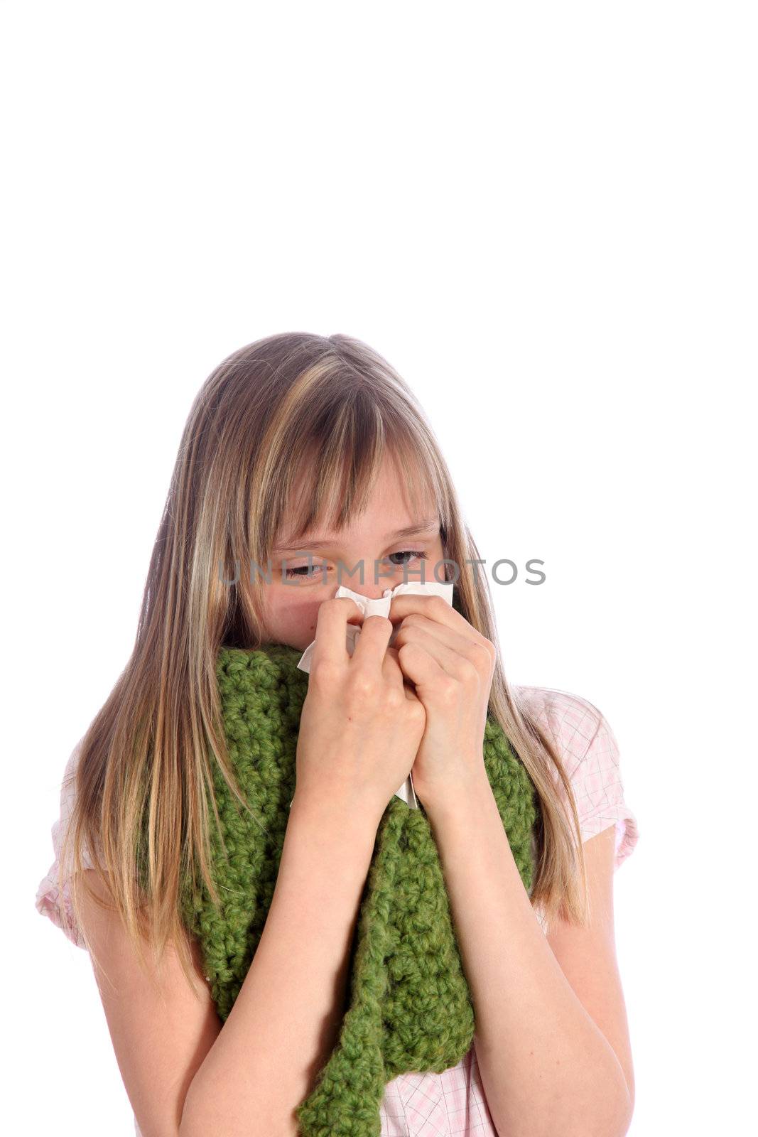 Sick, young girl with a scarf around his neck blows her nose 