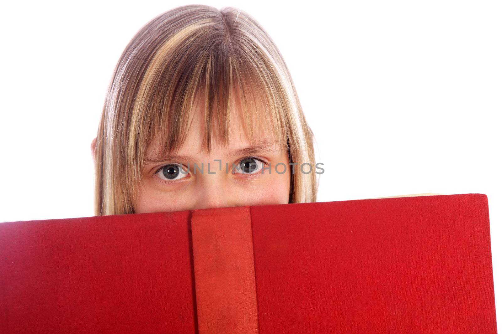 young girl looks out on a red book. Only the eyes are visible
