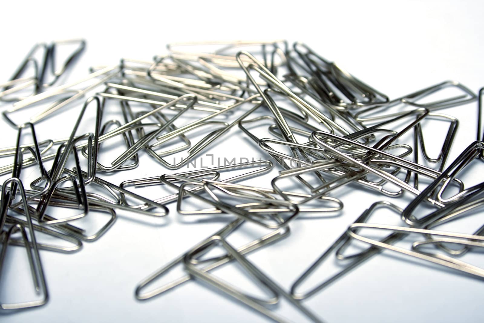 Writing paper clips on white background. Shallow DOF
