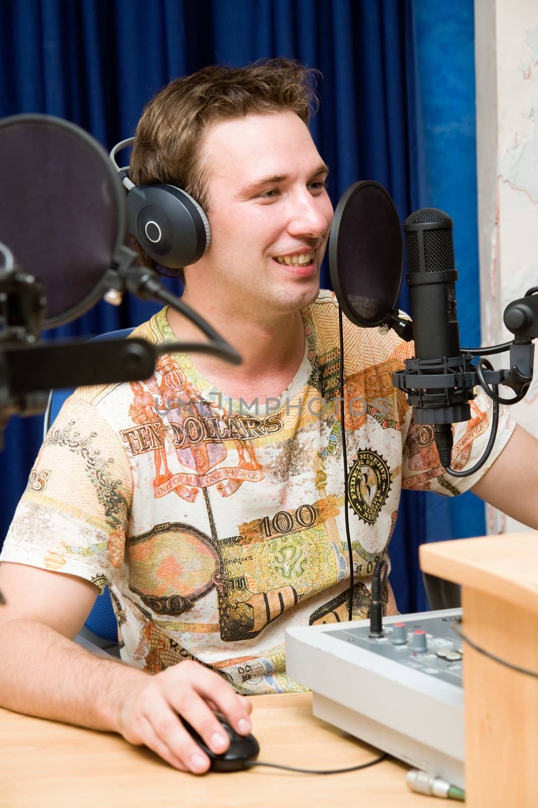 Radio DJ.  Young man with microphone and big headphone.