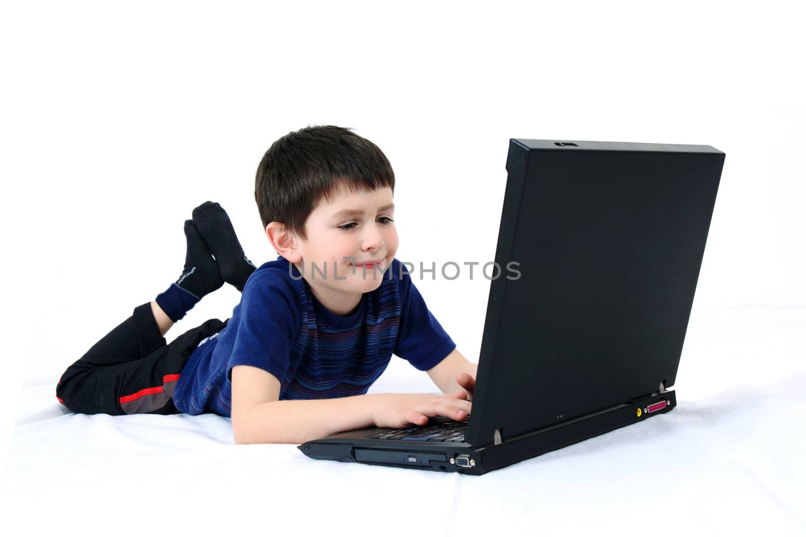 small boy playng game on laptop on a white background 