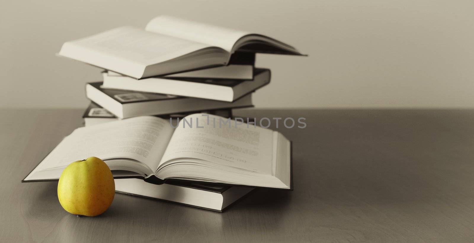 green apple and opened books on sepia background