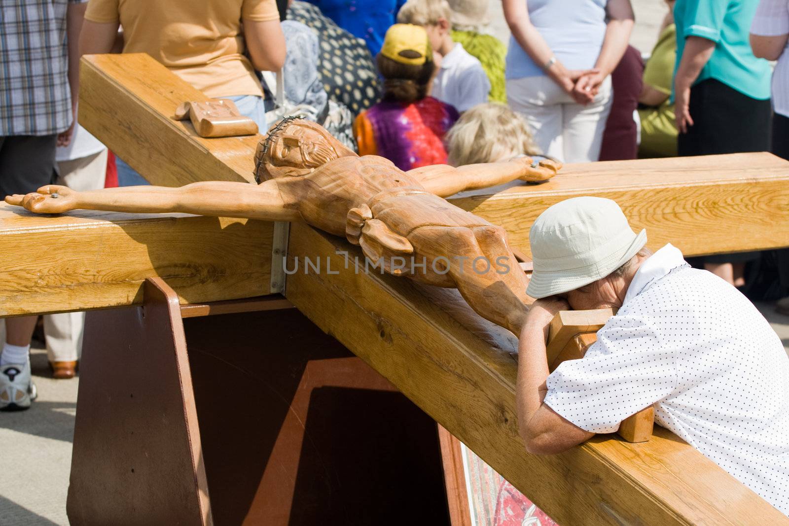 Praying woman at large wooden crucifix. Day of the Assumption of Mary (15th August) Aglona, Latvia.