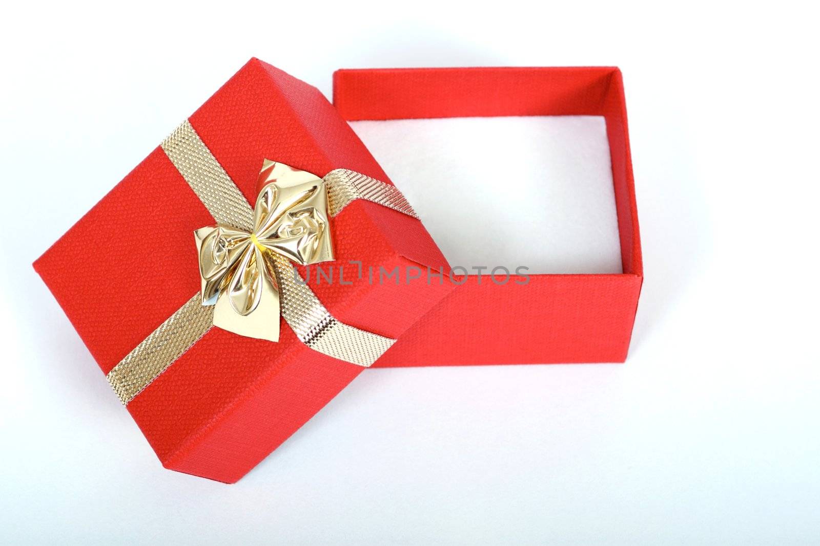 red present box with gold ribbon isolated on white by artush