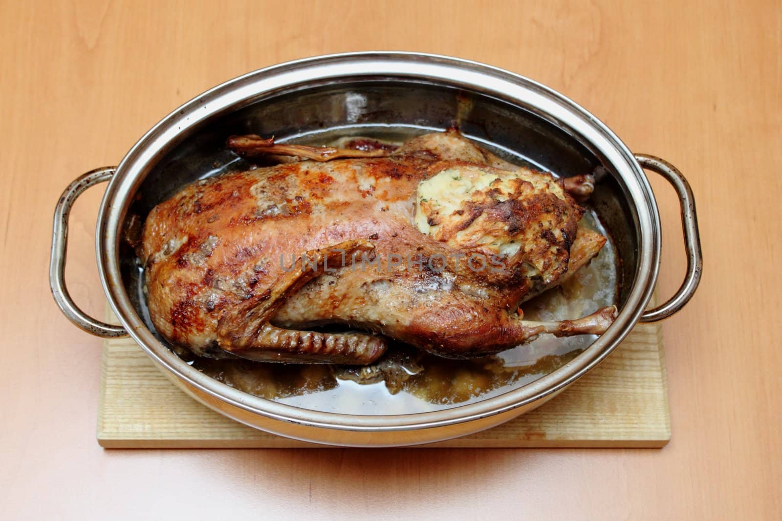 Roasted duck in pan on the wooden desk