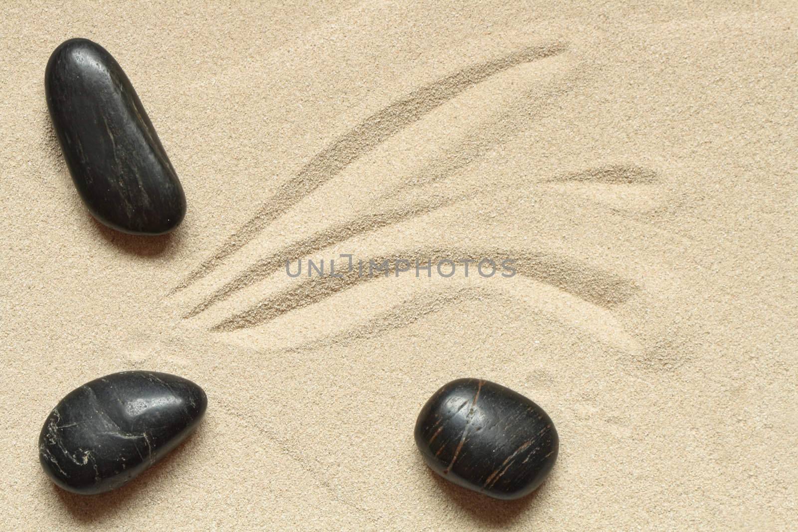 Abstract sand background with lines and black stones