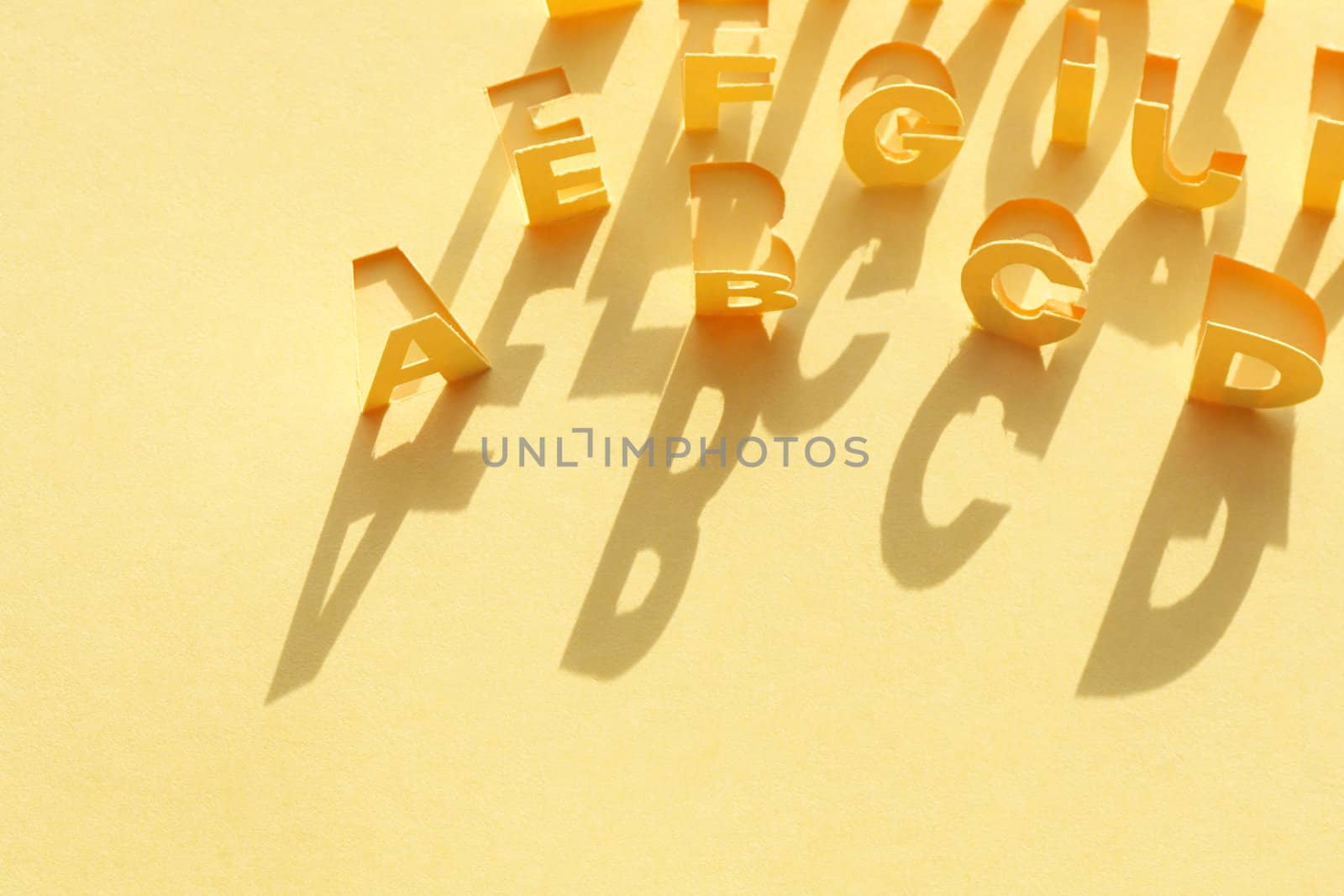 Alphabet made from cutting yellow paper sheet