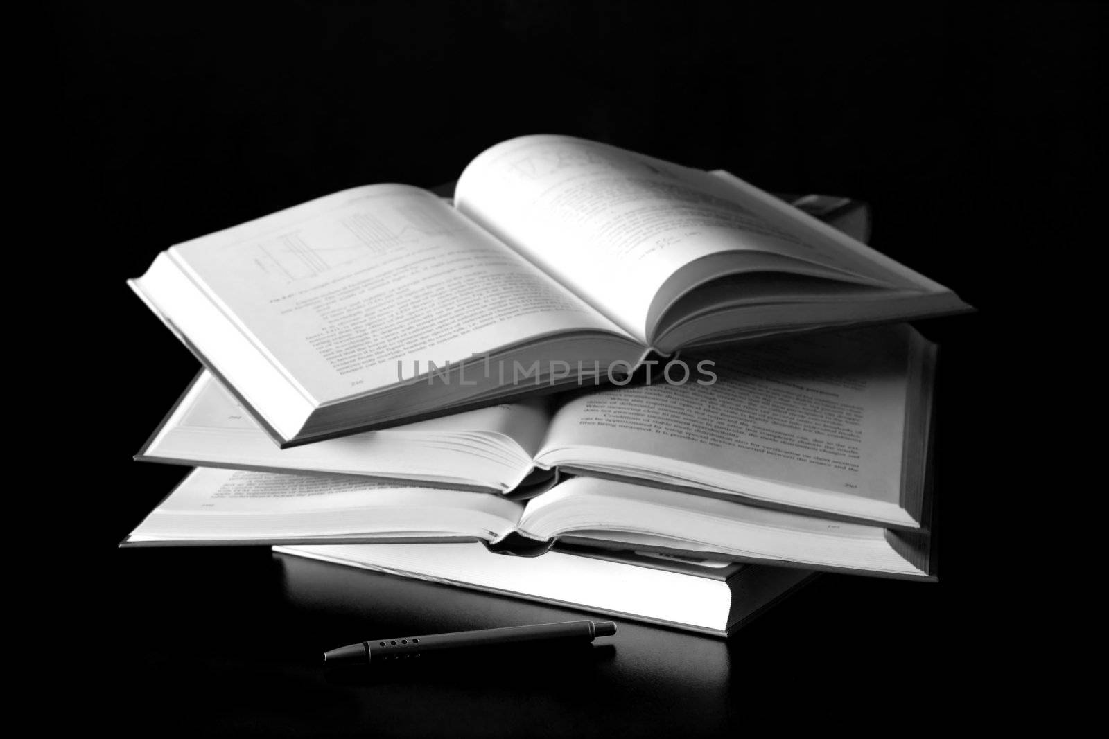 books on black background with pen for background use