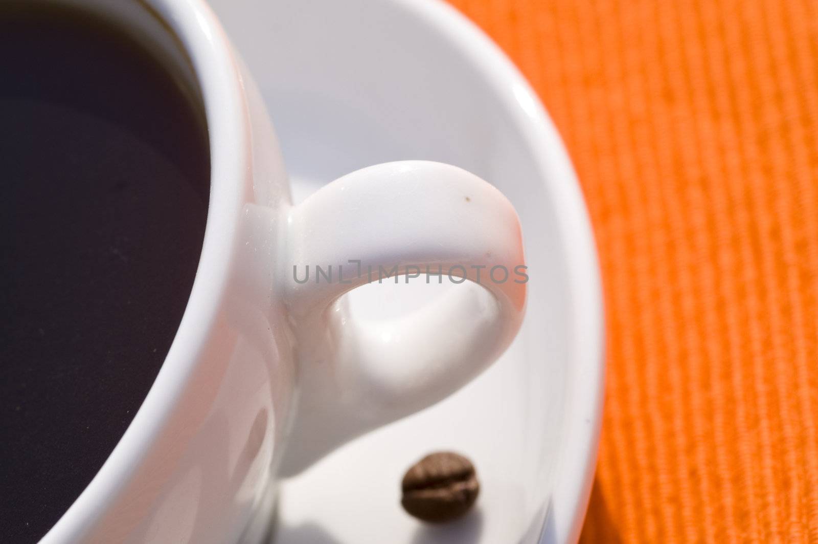 closeup on a coffee cup on orange background