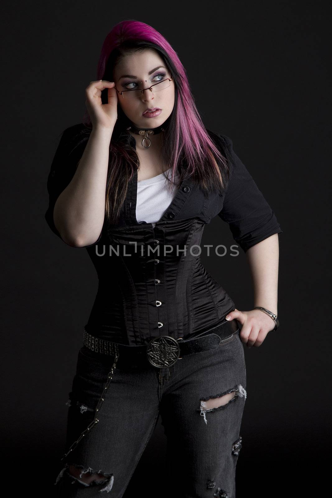 Goth girl with pink hair and body piercing holding her glasses