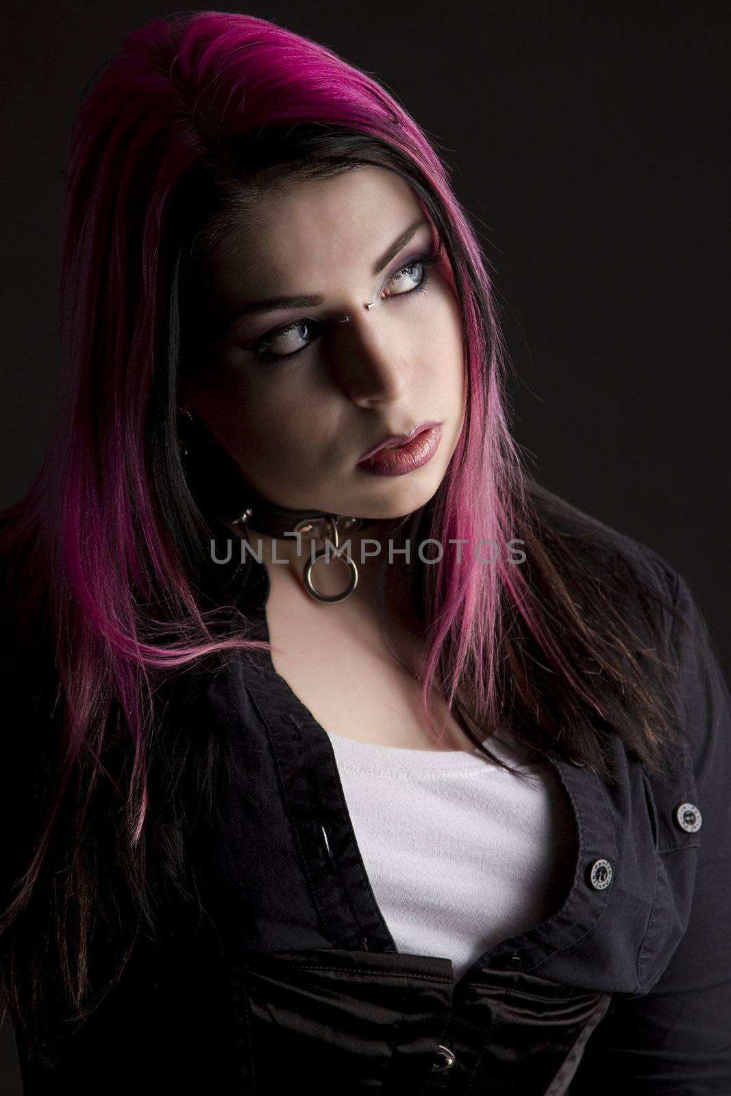 Goth girl with pink hair and body piercing looking to the right