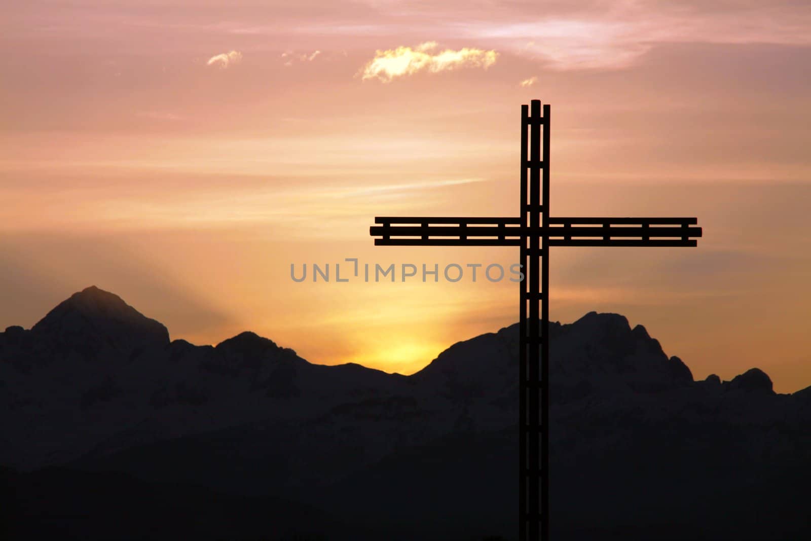 Religious cross. Mountains in sunset in the background