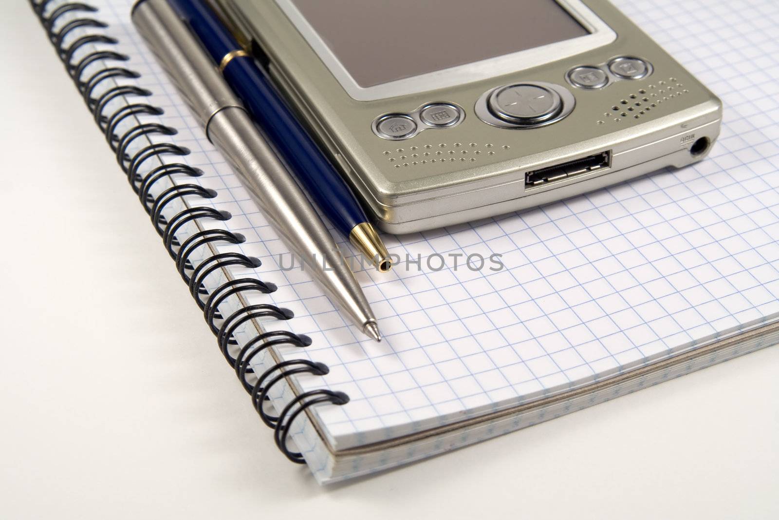 Two pens and PDA on spiral notebook by serpl