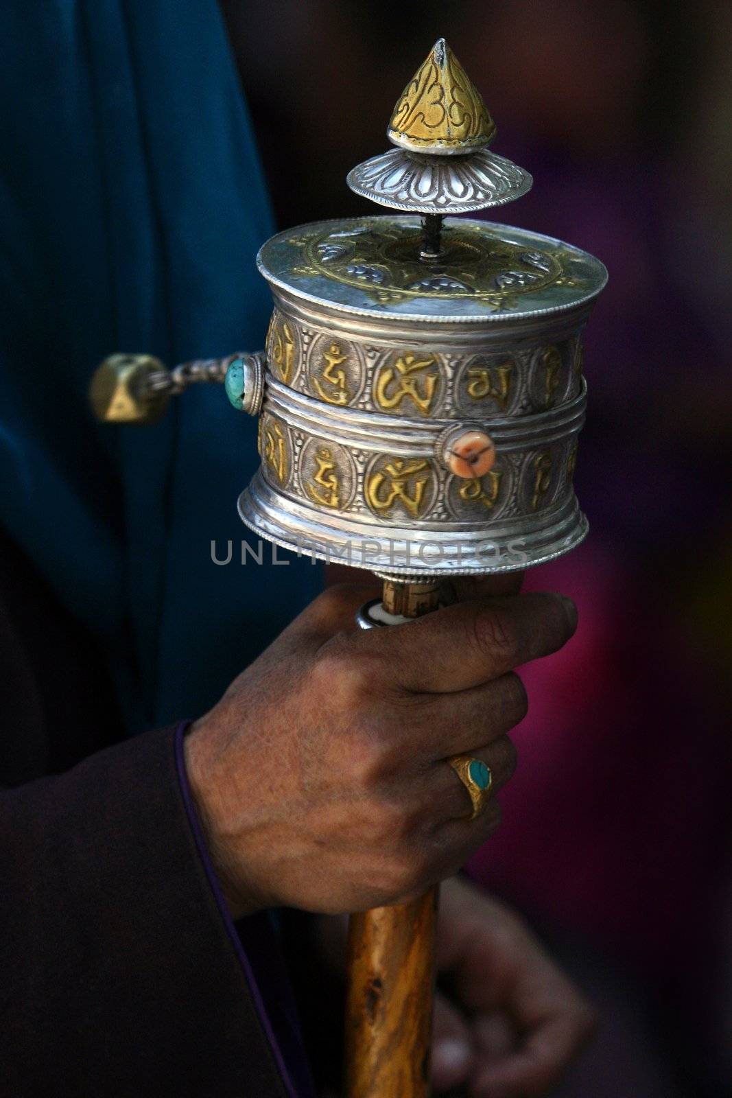 Tibetan Buddhist prayer wheel in the hand of local man, Leh, India