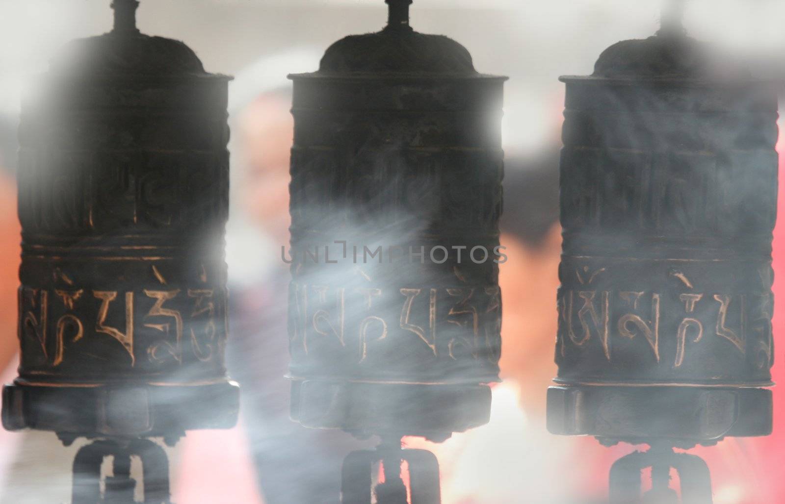 Tibetan Buddhist prayer wheels, smoke in the background