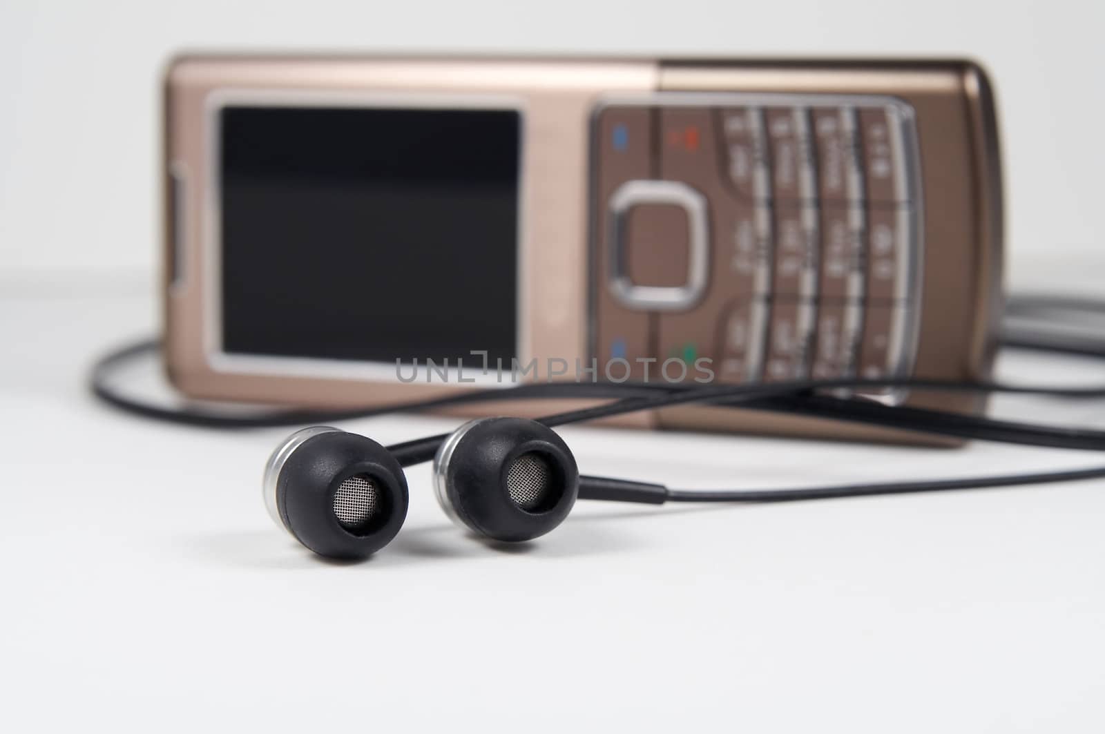 Headphones with mobile phone on background. Shallow depth of field