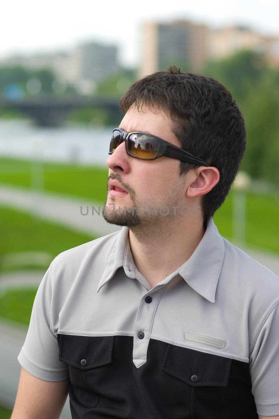 Young man with his mouth open looking up at something in astonishment on city view background