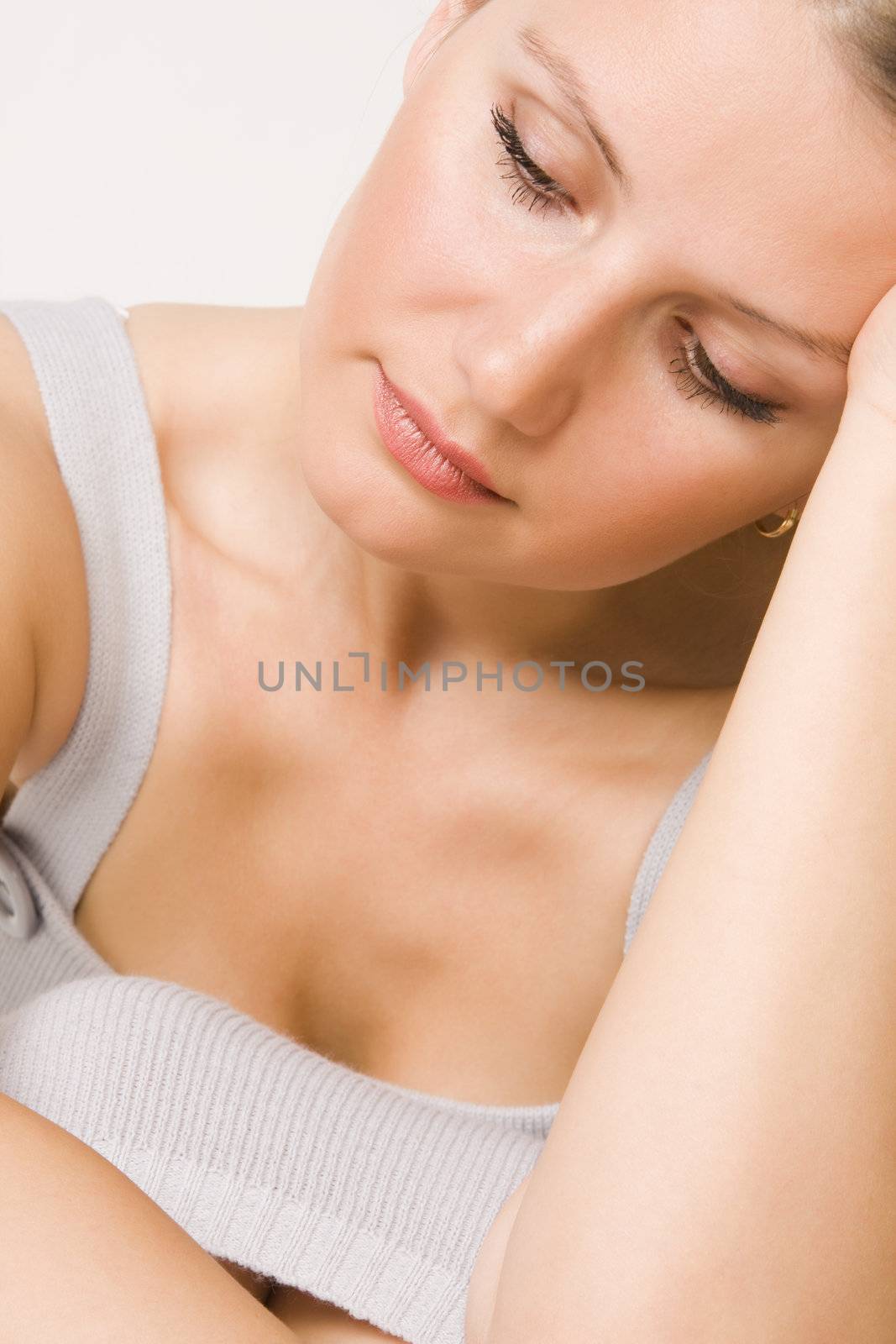 Portrait of young beautiful sad woman on white background