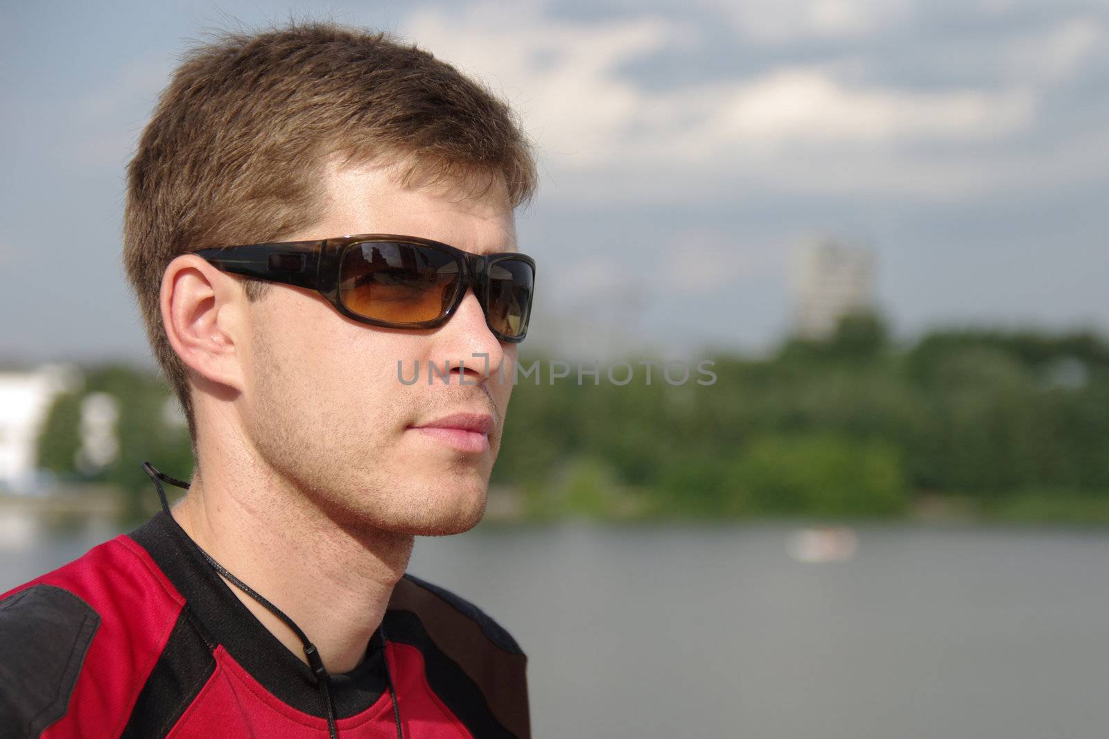 Young sportsman on city view background looking at something