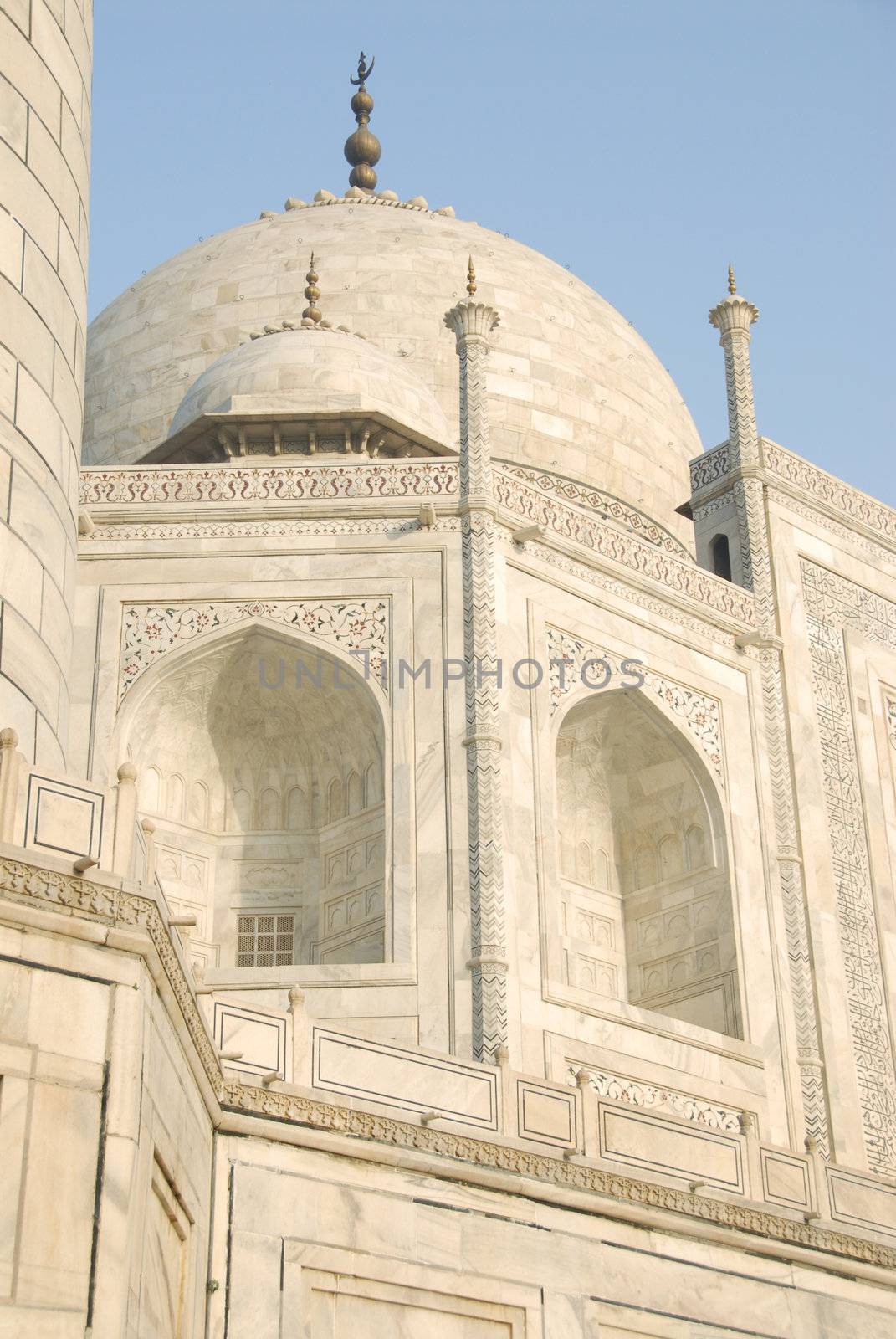 Upward Point of view of the Taj Mahal mausoleum in Agra, India showing the the primary dome as well as a corner dome and the edge of the minaret to form a side border