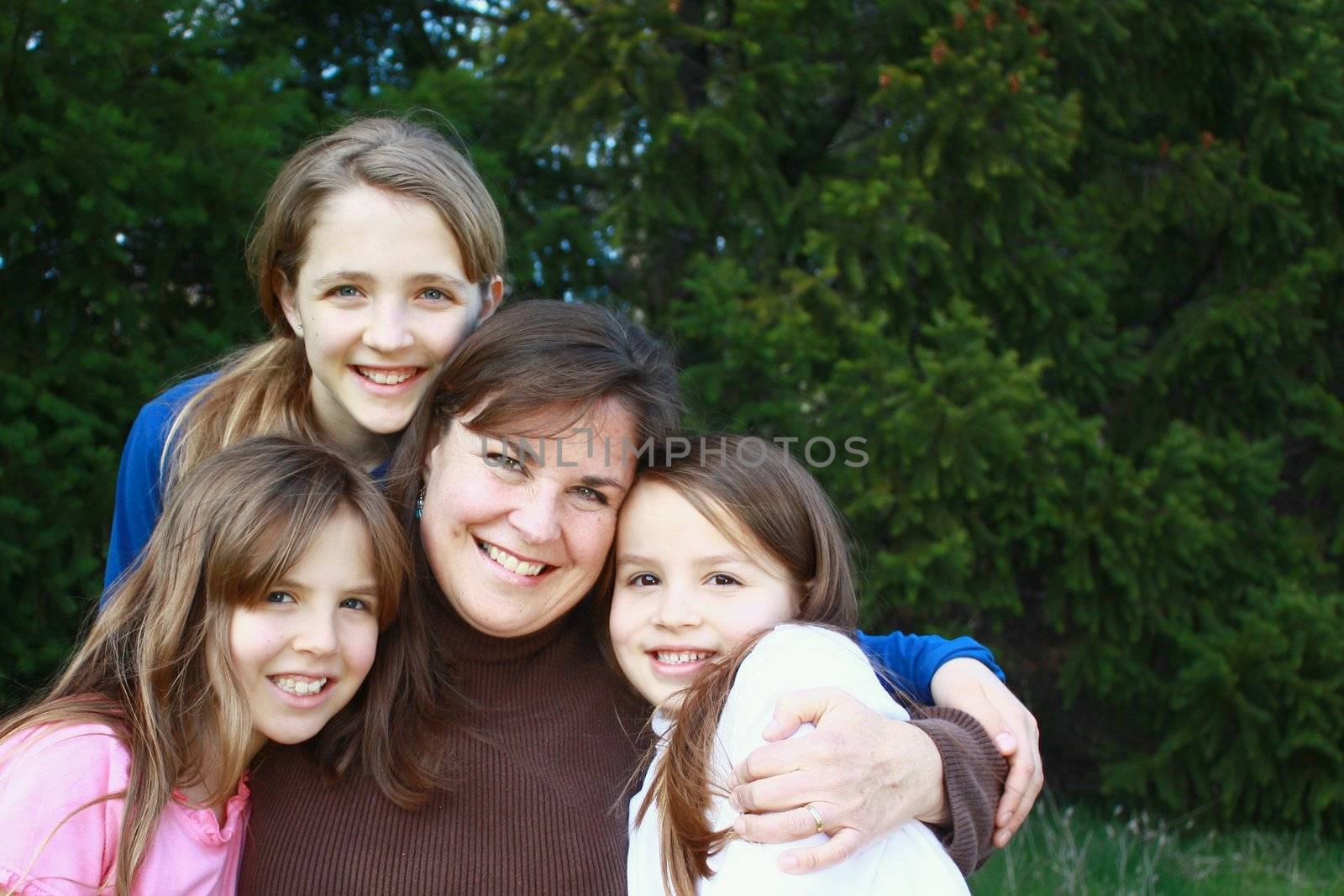 Mother and three daughters with green trees in background