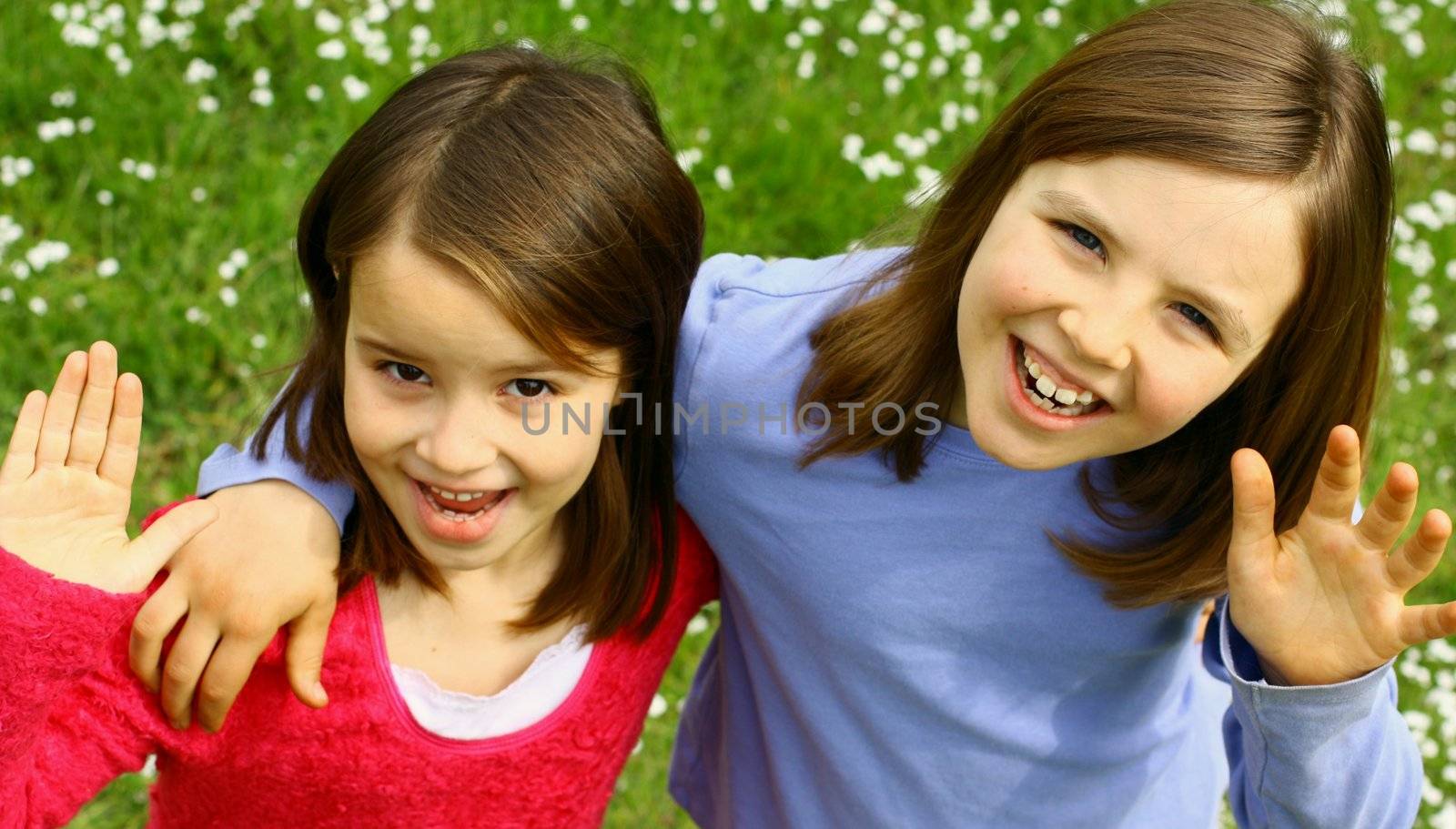 Two sisters waving