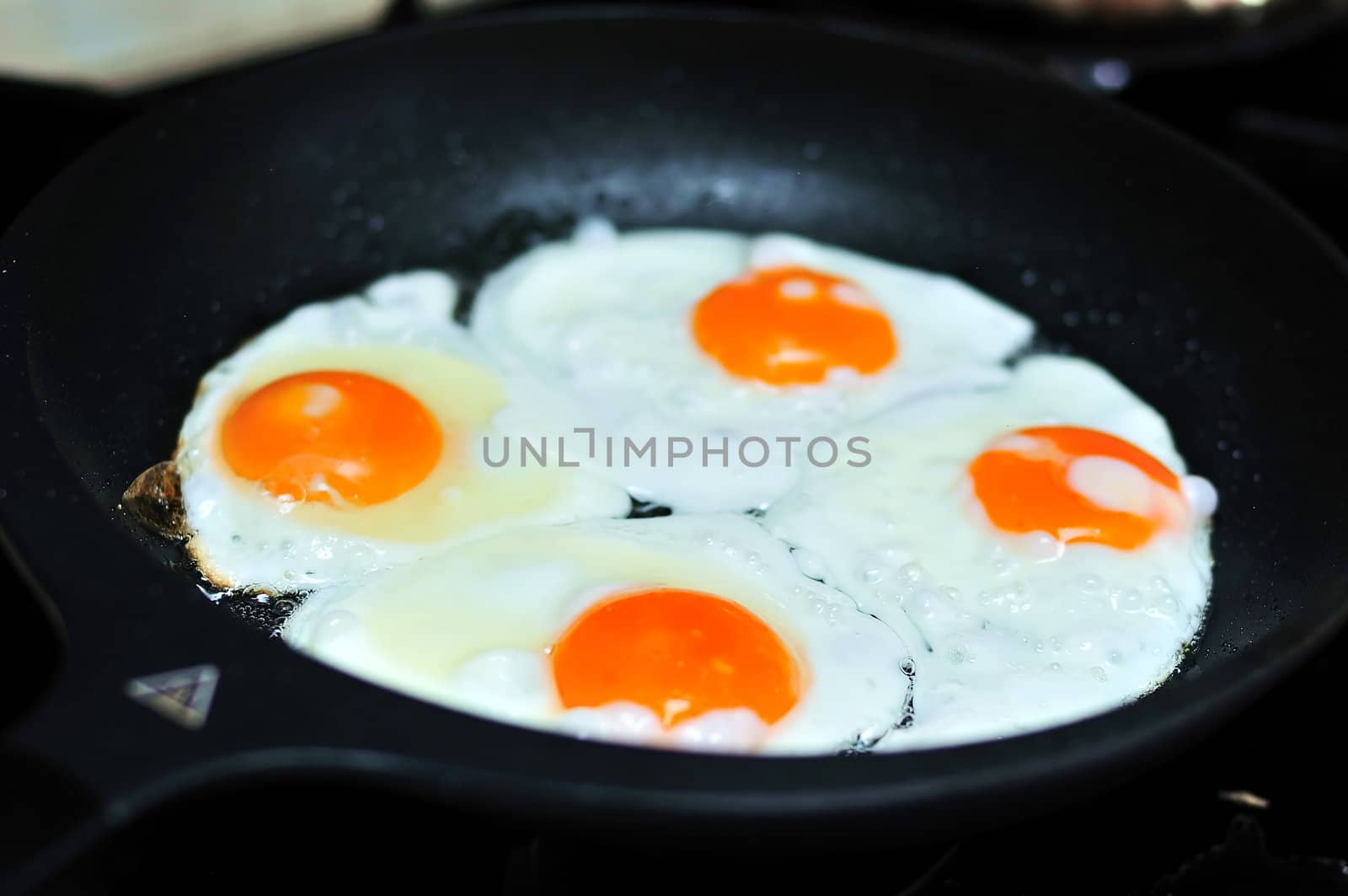 four fried eggs in a frying pan
