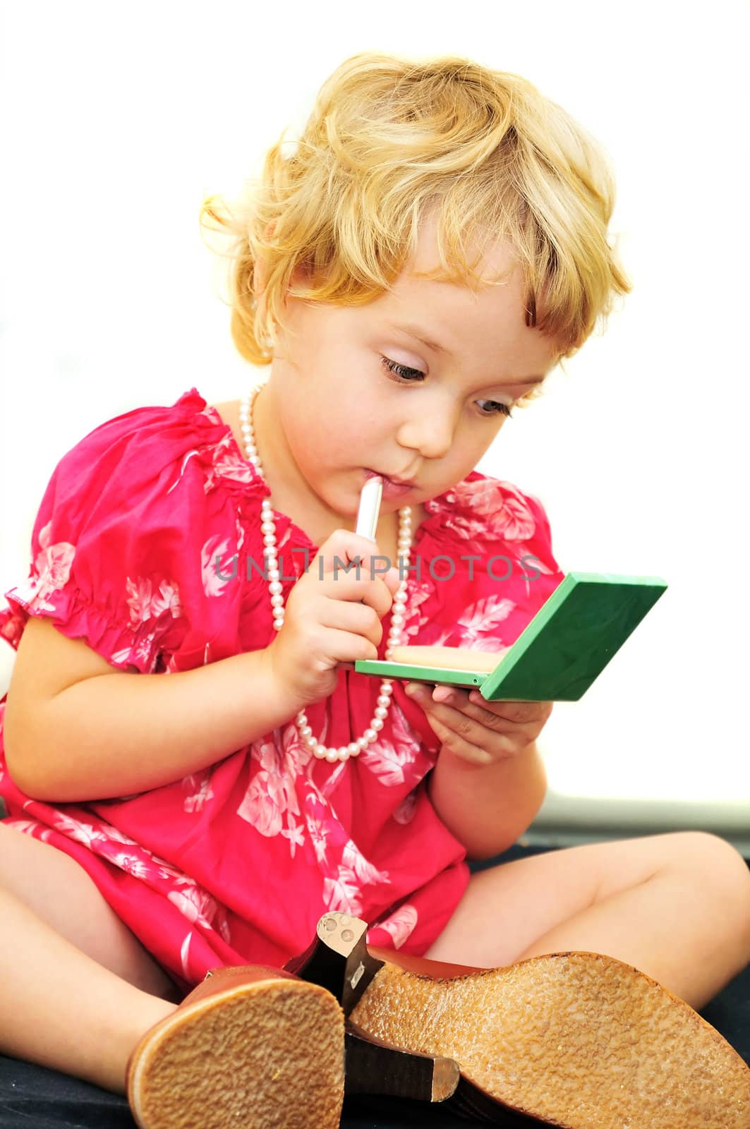 pretty little girl usinf mother's cosmetics