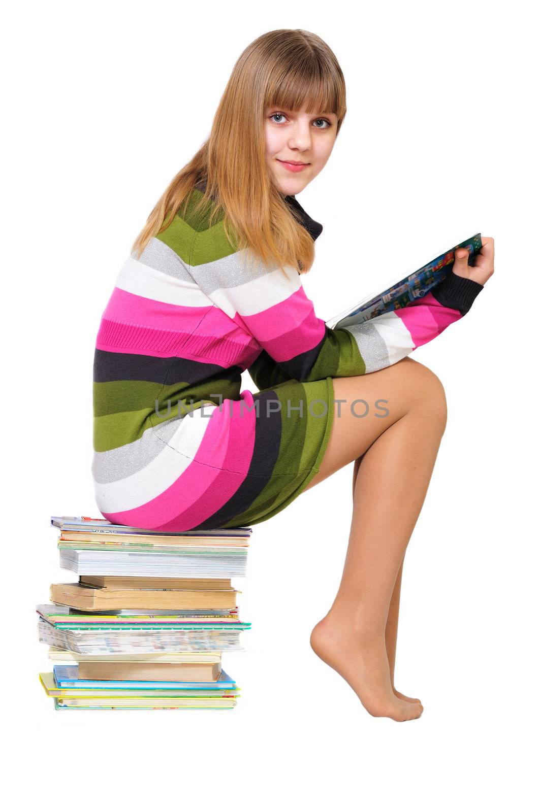 sweet teen girl sitting on the pile of books