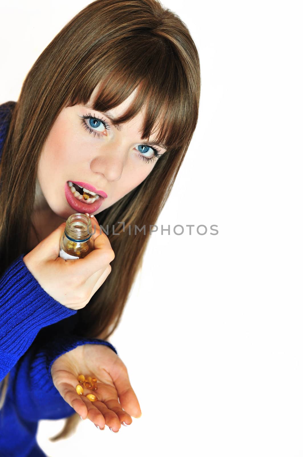 portrait of young woman girl taking pills, looking at camera