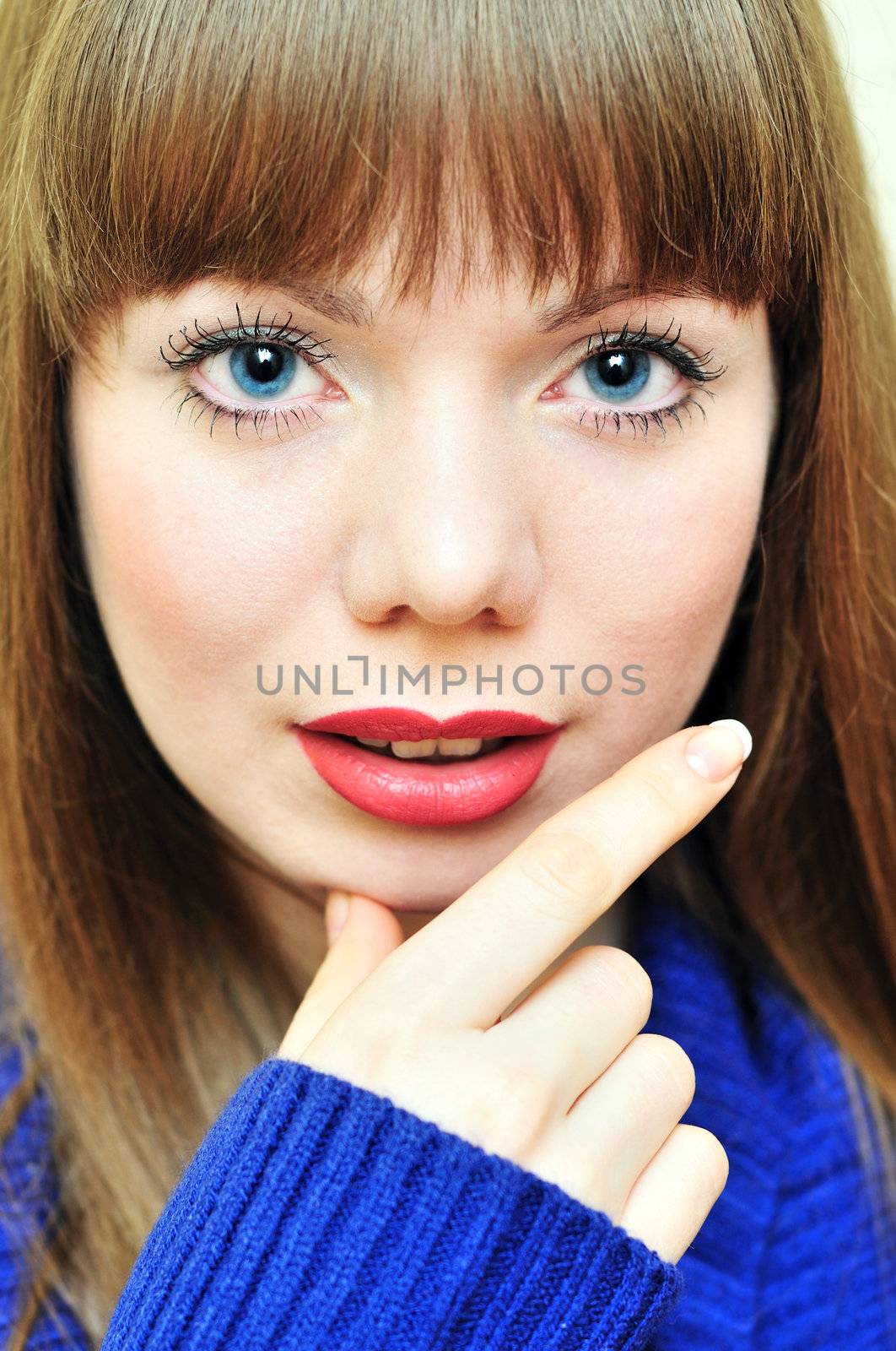 thoughtful young beautiful woman wearing blue sweater