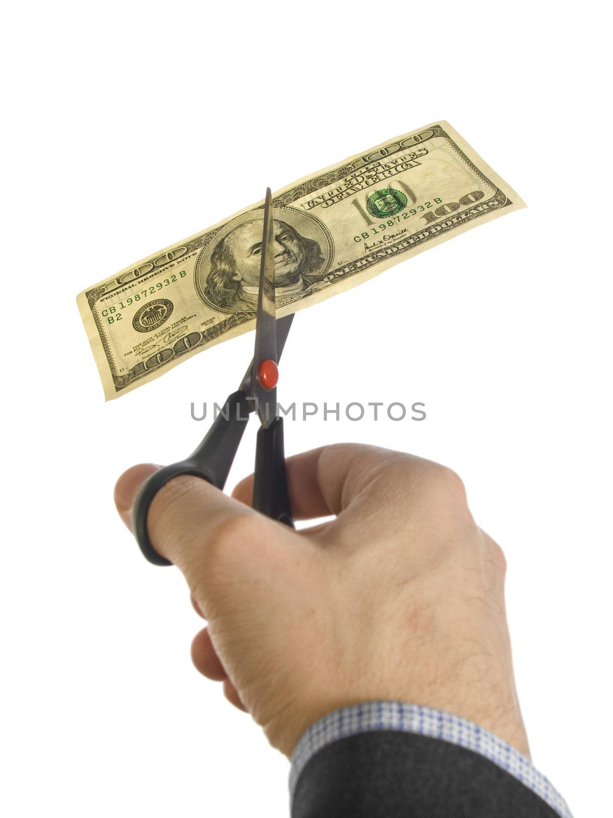 A man's hand cutting a one hundred dollar bill with a pair of scissors.