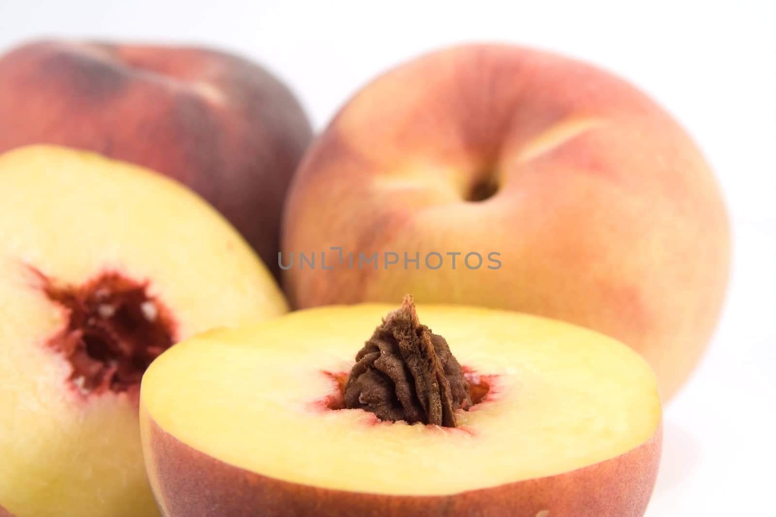 Peach with seed foreground. Shalow depth of field with focus on pit.