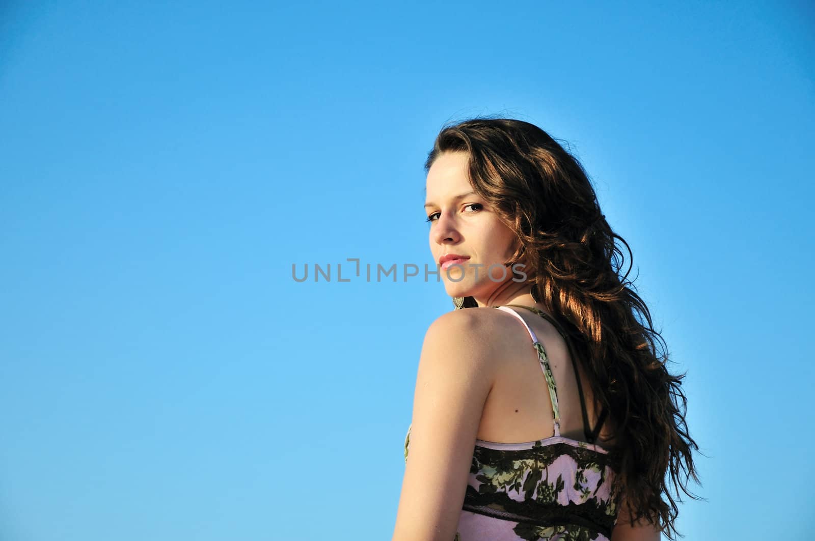  pretty  brunette longhaired girl over the blue sky

