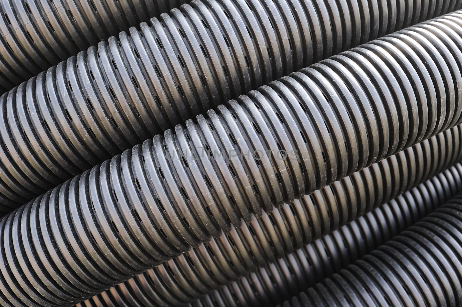 Close up of the pattern formed by a coil of black plastic pipework, suitable as abstract background.