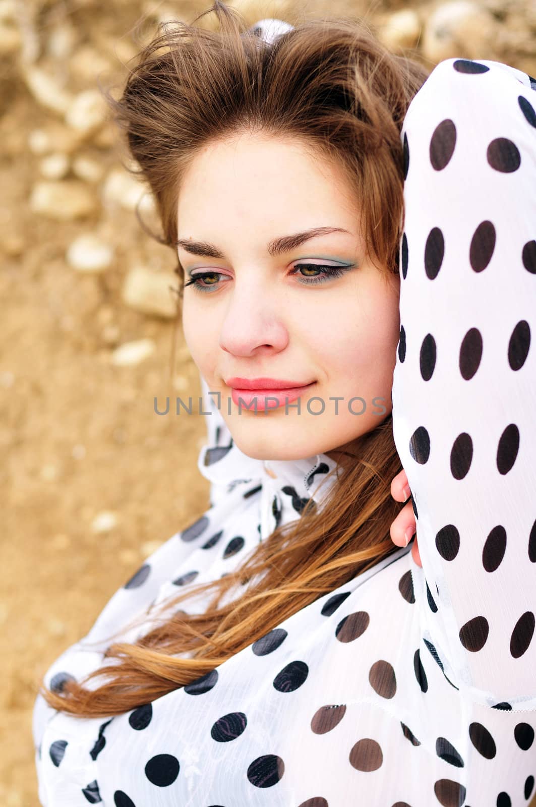 beautiful young girl wearing spotted blouse outdoors