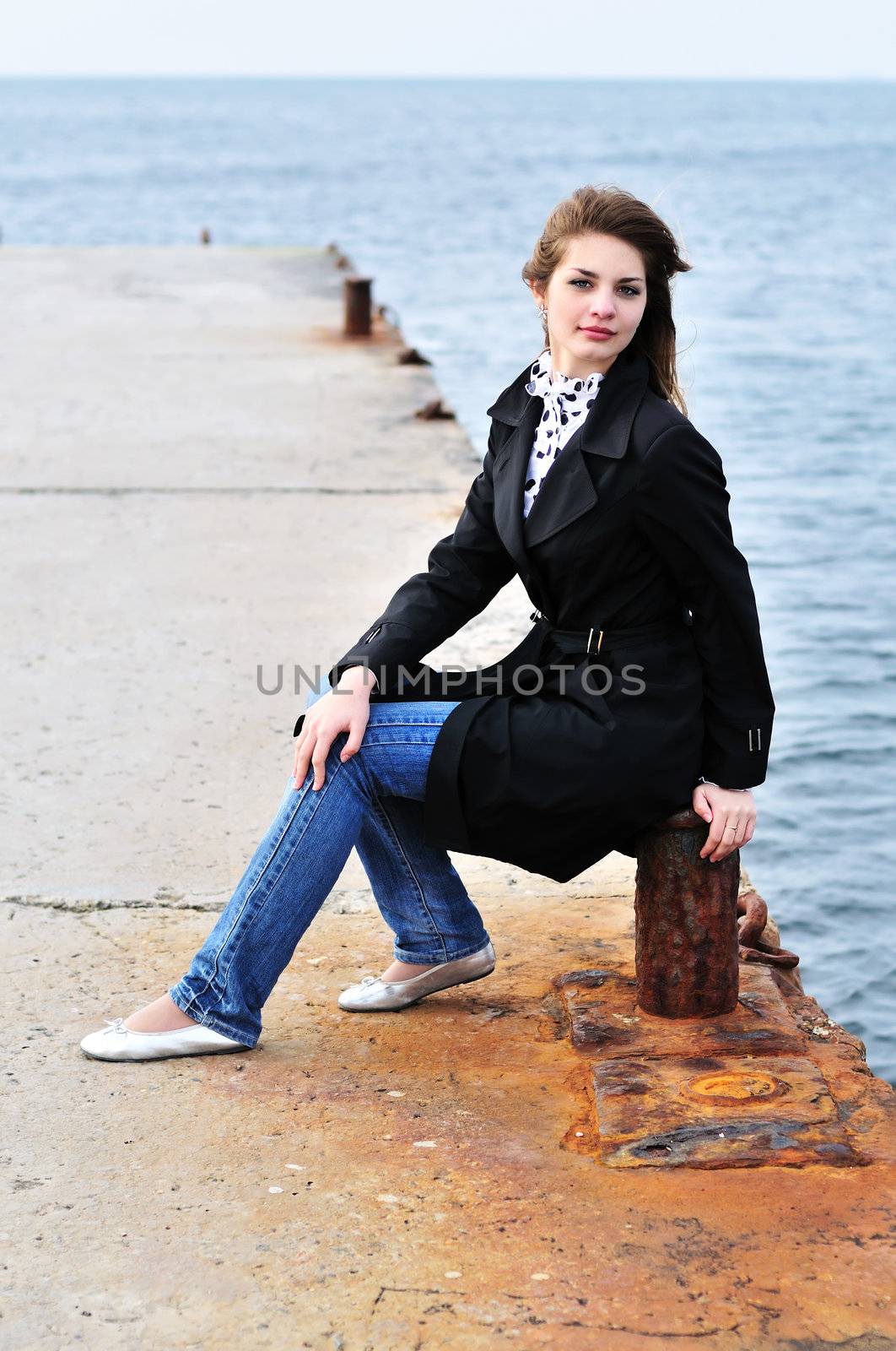  teen girl sitting on the dock by Reana