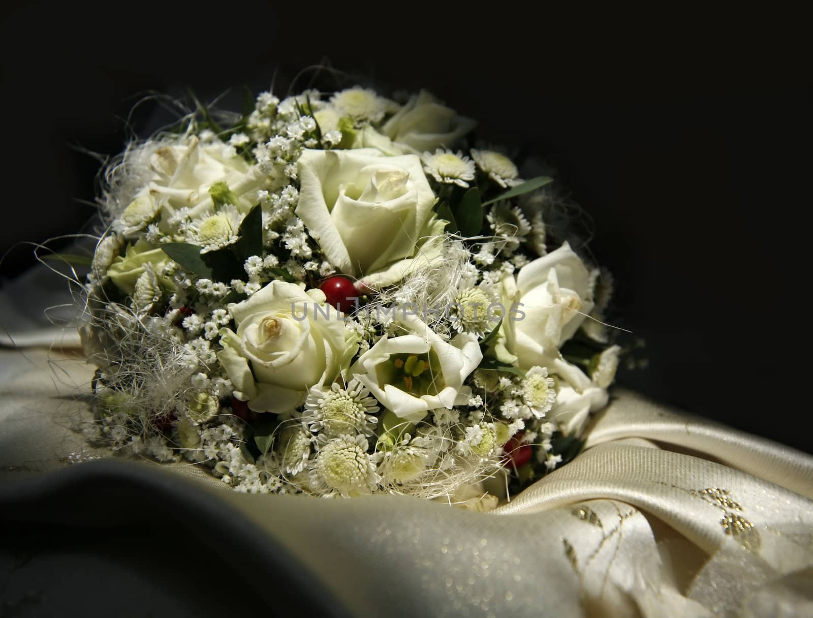 Wedding bouquet from roses and chrysanthemums on a background of a dress