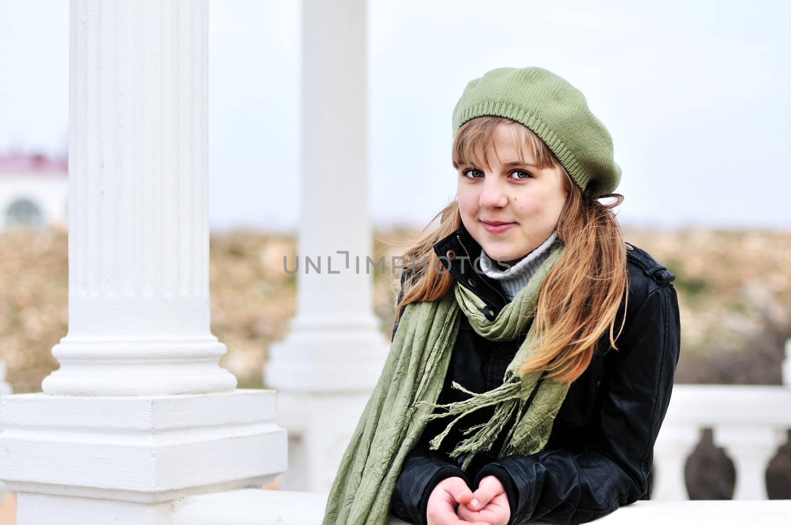 lovely teen girl standing near the columns
