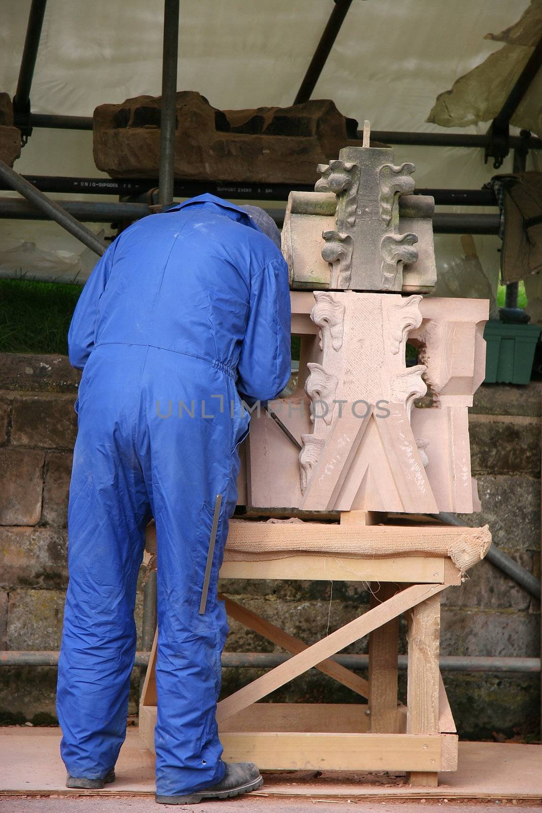 stone mason, hard at work carving a piece of stone