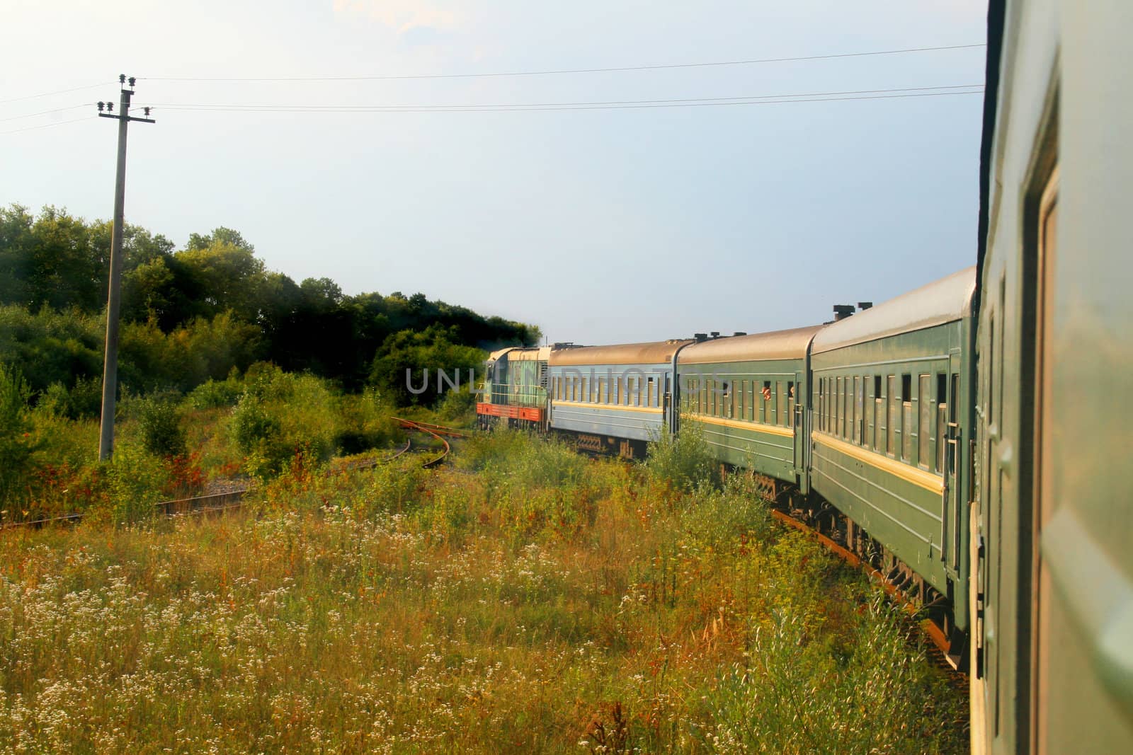Eastern european train entering into a forested area of track