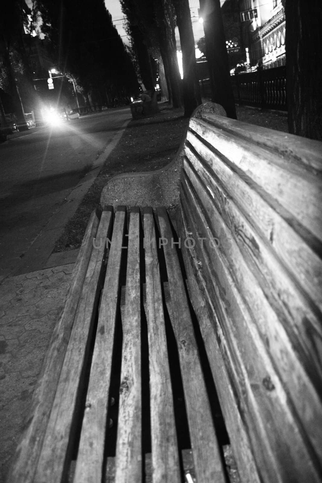 Black and white image of a bench in empty park