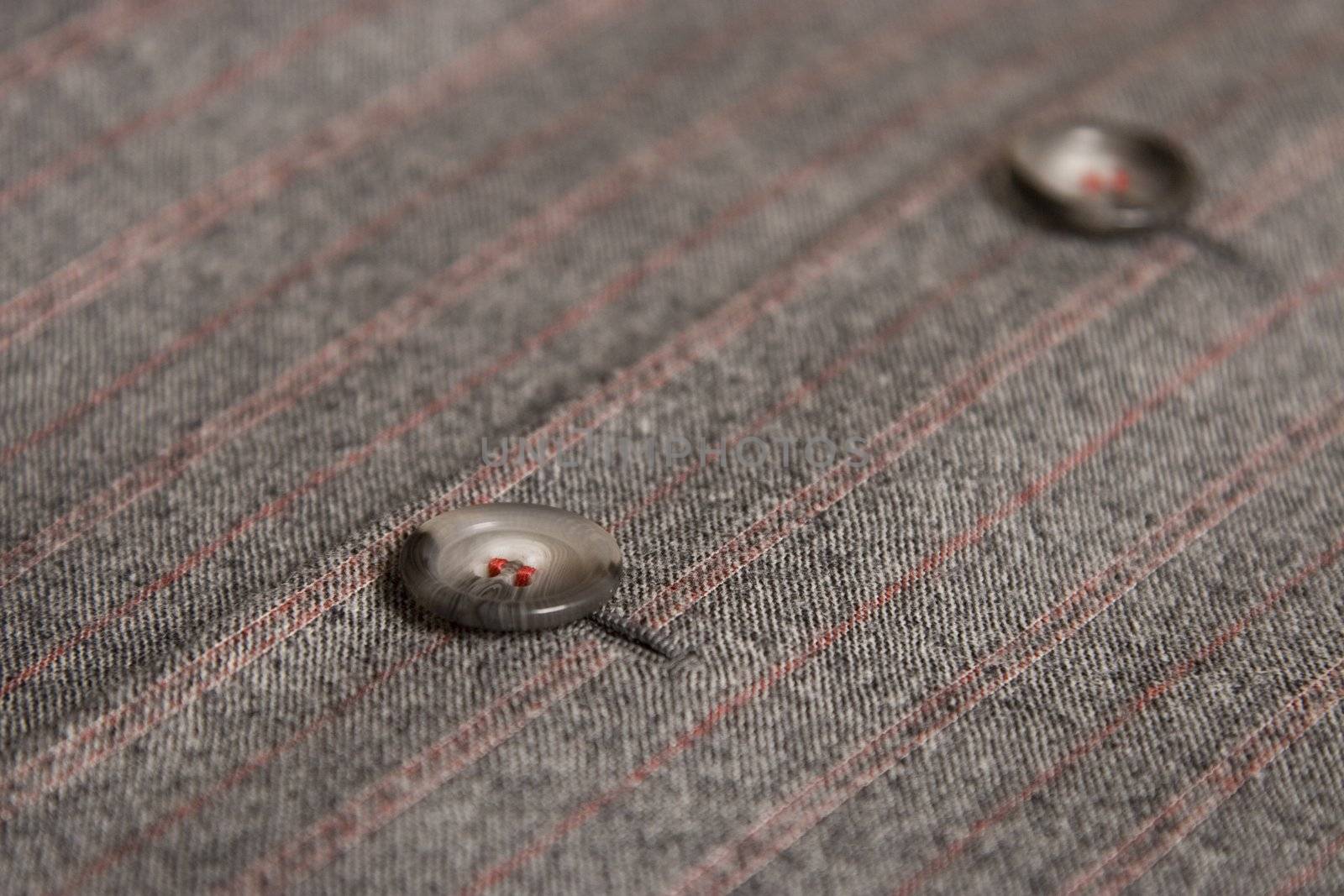 two buttons from classic coat and red thread