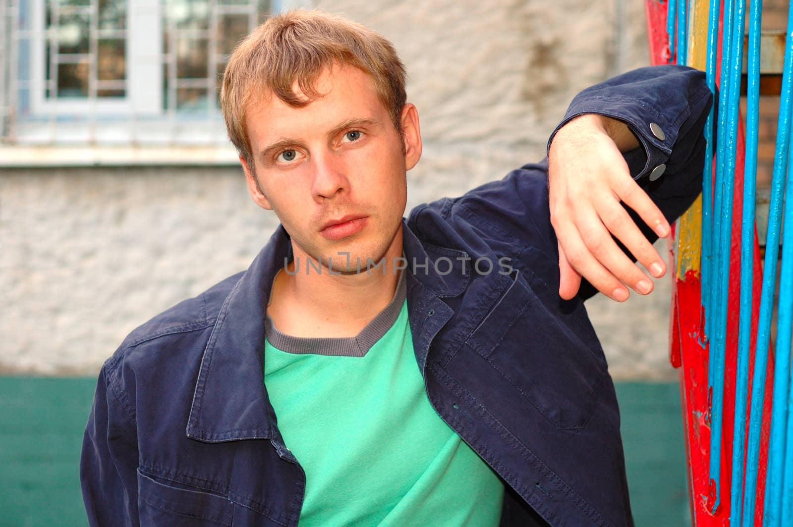 Young stylish man with blonde hair stand near handrail.