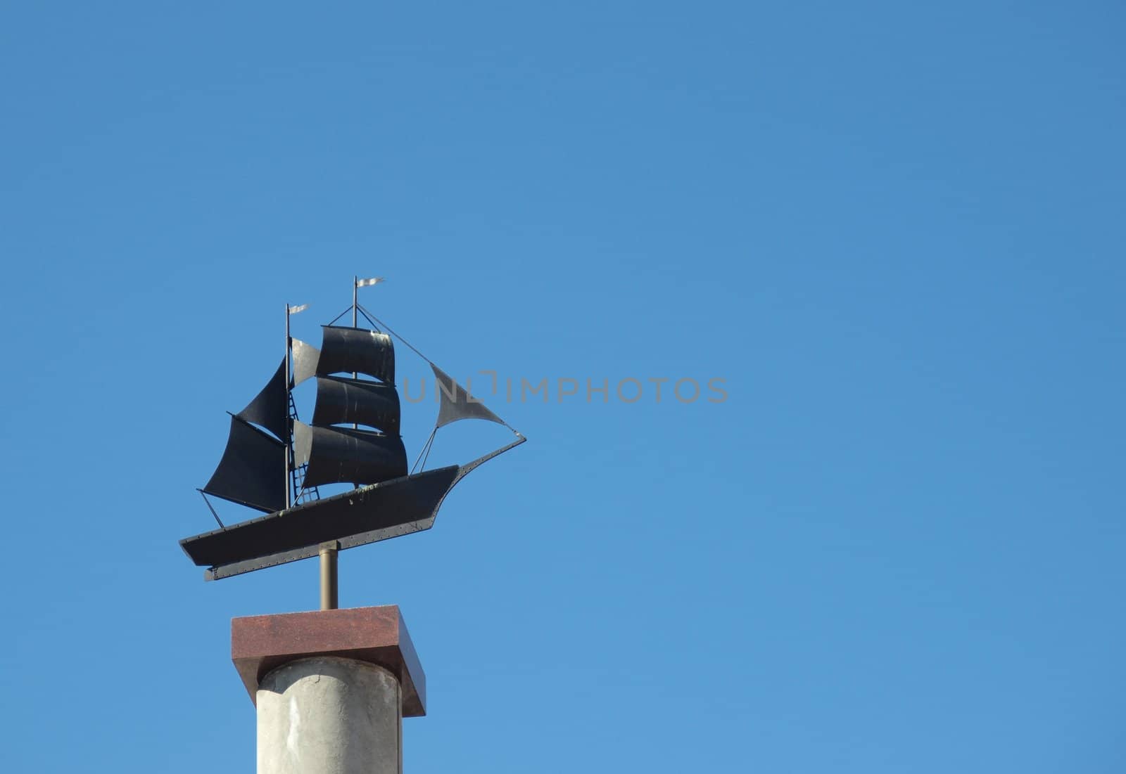 Sculpture of the ship on a background of the dark blue sky    
