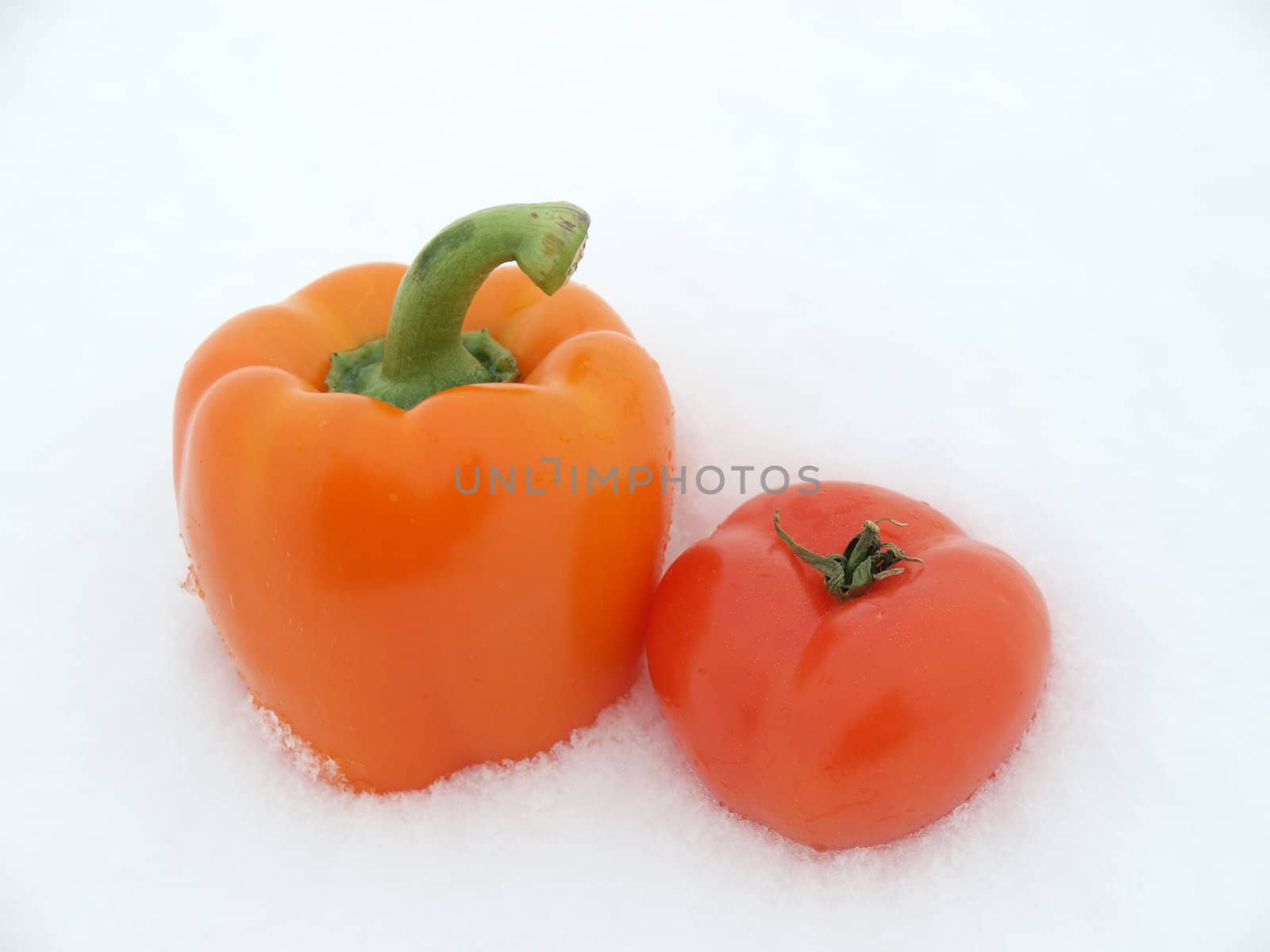 Pepper and tomato on a snow        