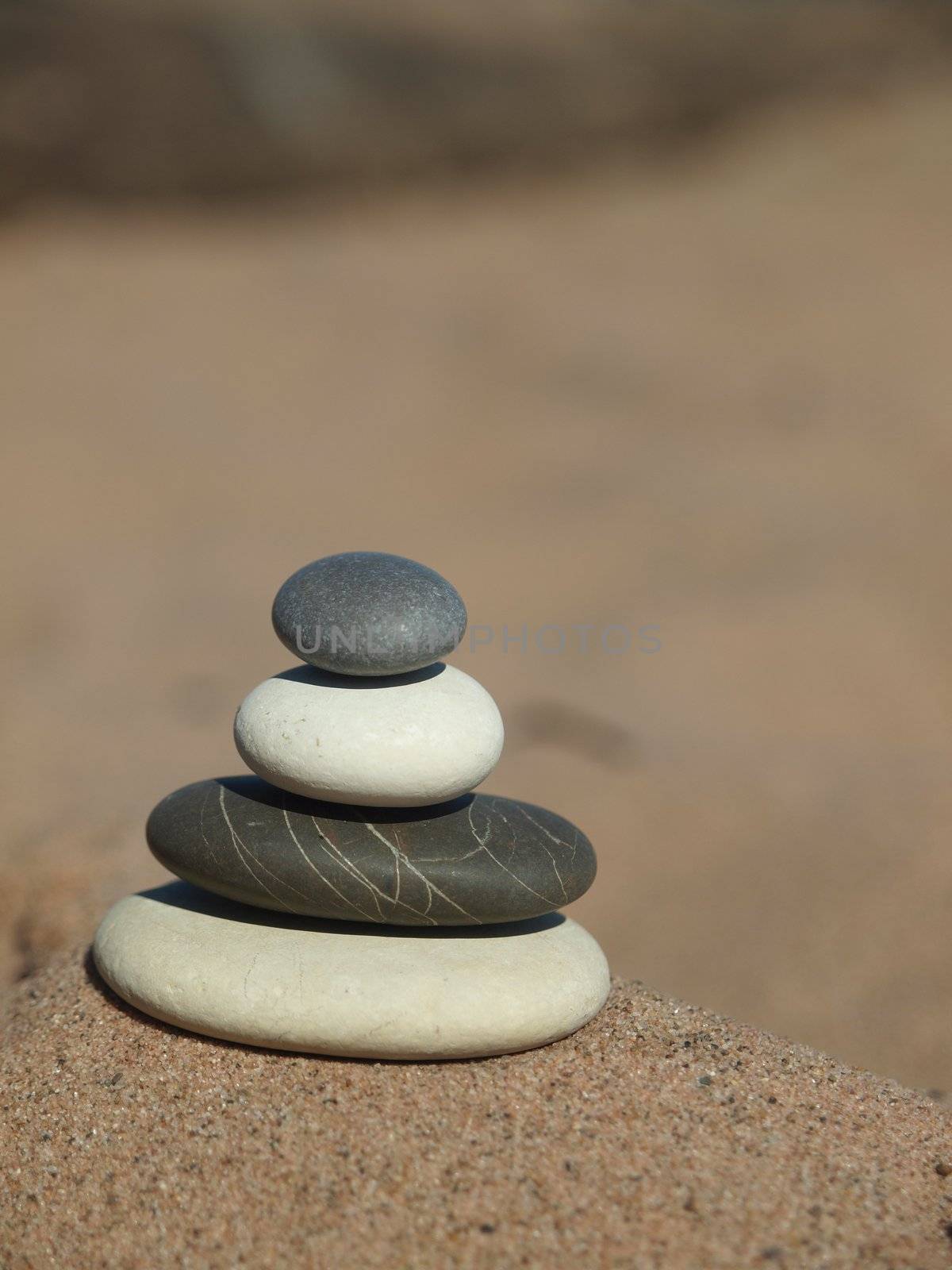 Black, white and grey pebble on sand on coast of lake          