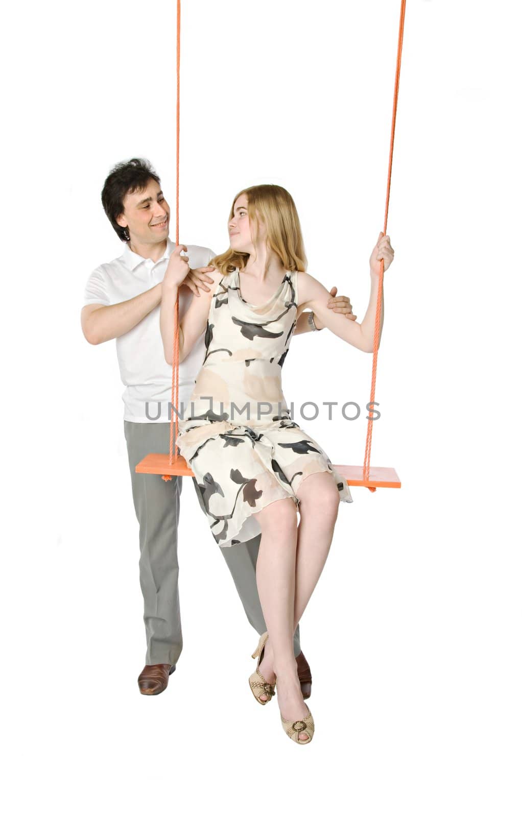 A man and a girl sitting on a swing