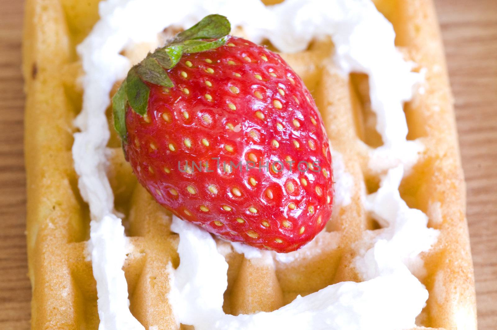 closeup on strawberry and whip cream waffle