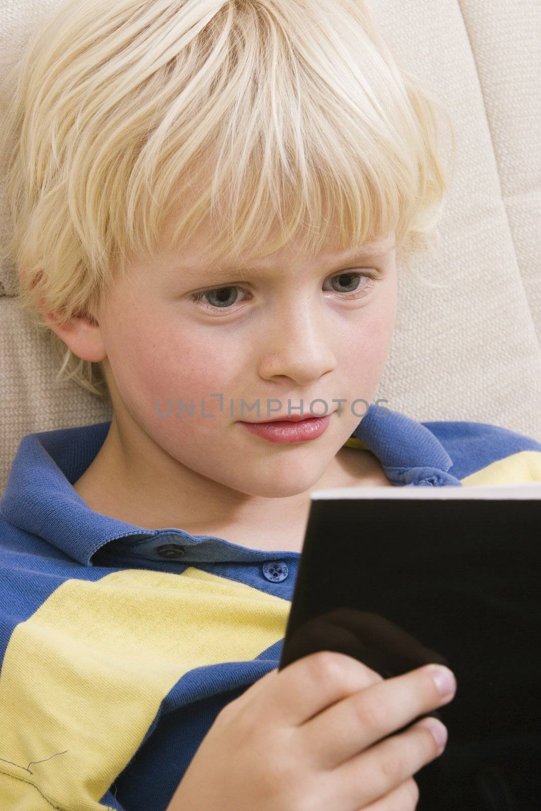 Cute little boy reading a book